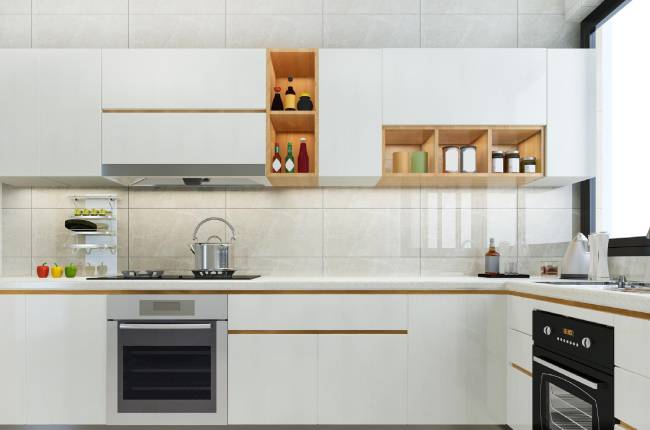 Modern kitchen with white cabinets, a gas stove with a pot, an oven, and open shelves displaying bottles and jars. Countertops are clean and a window provides natural light.